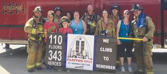  bunch of people in front of a fire turck holding up a banner